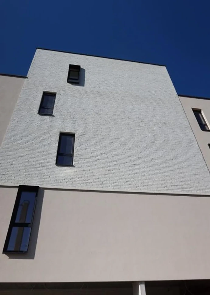 photo façade avant en contre plongée crépi et briquette blanc appartement